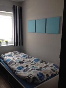 a bed with a blue and white comforter in a bedroom at NEU! Modernes Ferienhaus Strandgut in Garrel