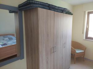 a wooden cabinet in a bedroom with a bed at NEU! Nordsee-Ferienwohnung Nicki in Dornum