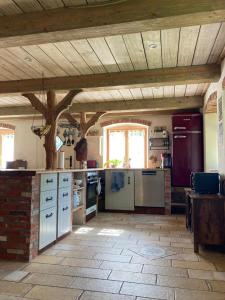 een grote keuken met een bakstenen vloer en een houten plafond bij NEU Feriendomizil Nordfriesland Pur in Braderup