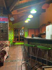 uma cozinha com um bar com bancos num quarto em Hostel Ruca Potu em Mendoza