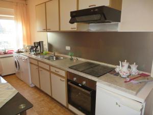 a kitchen with a sink and a stove top oven at Ferienwohnung Aurich Ostfriesland in Aurich +8 photos