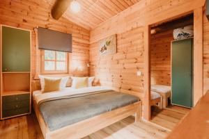 a bedroom with a bed in a wooden cabin at NEU! Komfort Ferienhaus Tannenrauschen in Hohegeiß