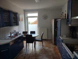 a kitchen with blue cabinets and a table and chairs at FeWo Franja Angermünde in Angermünde +2 photos