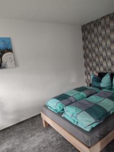 a bedroom with a bed with blue pillows at FeWo Franja Angermünde in Angermünde