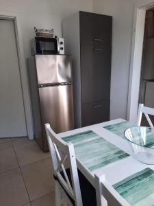 a kitchen with a table and a stainless steel refrigerator at NEU! Kleinstadtferienhaus Grimmen in Grimmen