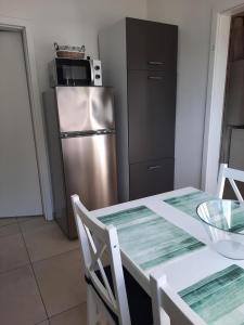 a kitchen with a table and a stainless steel refrigerator at NEU! Kleinstadtferienhaus Grimmen in Grimmen +18 photos