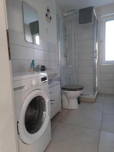 a white bathroom with a washing machine in it at NEU! Kleinstadtferienhaus Grimmen in Grimmen