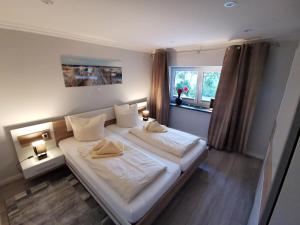 a bedroom with a large bed with two pillows at NEU! Ferienhaus Musenburg Apartment W1 in Stedesand