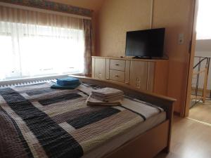 Schlafzimmer mit einem Bett und einem Flachbild-TV in der Unterkunft NEU! Schöne Nordsee-FeWo Kölker in Nenndorf