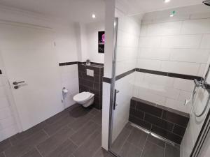 a bathroom with a shower and a toilet in it at NEU! Ferienhaus Musenburg Apartment W1 in Stedesand