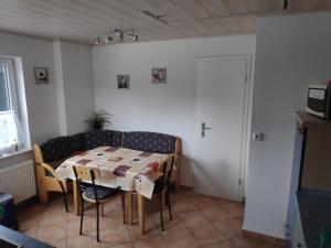 ein Esszimmer mit einem Tisch, Stühlen und einer Tür in der Unterkunft NEU! Ferienhaus NordseeGlück in Dornum