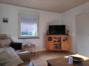 ein Wohnzimmer mit einem Sofa und einem Flachbild-TV in der Unterkunft NEU! Ferienhaus NordseeGlück in Dornum
