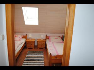 ein kleines Zimmer mit 2 Betten und einem Fenster in der Unterkunft NEU! Ferienhaus NordseeGlück in Dornum