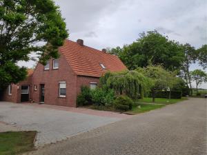 einem roten Backsteinhaus mit Auffahrt in der Unterkunft NEU! Ferienhaus NordseeGlück in Dornum