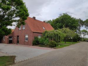 a red brick house with a driveway at NEU! Ferienhaus NordseeGlück in Dornum