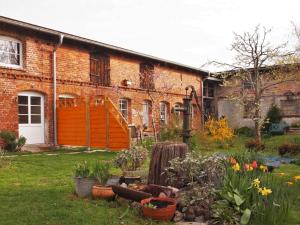 a brick building with a yard with flowers and plants at NEU Fewo im Bauernhaus mit idyllischem Innenhof und Naturgarten in Mesekenhagen +12 photos