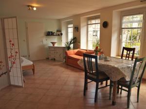a living room with a table and chairs and a couch at NEU Fewo im Bauernhaus mit idyllischem Innenhof und Naturgarten in Mesekenhagen