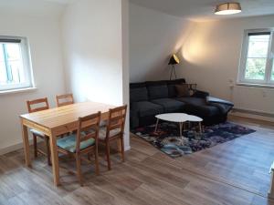 sala de estar con mesa y sofá en Ferienwohnung am Hambach, 