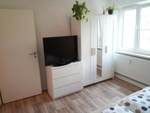 - un salon avec une télévision sur une commode dans l'établissement Ferienwohnung am Hambach, 