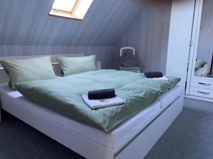 a large bed with green sheets and towels on it at NEU! FeWo am alten Deich mit Balkon in Osteel