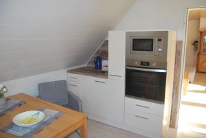 une petite cuisine avec un micro-ondes et une table dans l'établissement NEU! Schönes Urlaubsdomizil an der Nordsee, à Stedesdorf