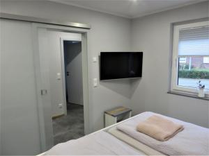 een slaapkamer met een bed en een flatscreen-tv bij NEU! Ferienhaus Nordeck in Berumbur