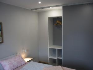een slaapkamer met een kast, een bed en een spiegel bij NEU! Ferienhaus Nordeck in Berumbur