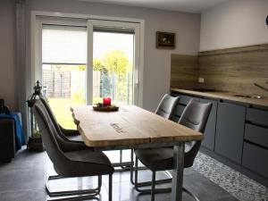 een keuken met een houten tafel en stoelen bij NEU! Ferienhaus Nordeck in Berumbur