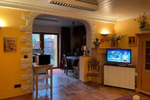 a living room with a television and a stone wall at Ferienwohnung Le Paradis in Bad Ems