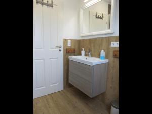 a bathroom with a sink and a mirror and a door at !!!NEU!!! Nordsee-Ferienwohnung Ahrendt in Westerbur