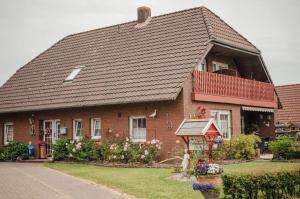 a large brick house with a gambrel roof at !!!NEU!!! Nordsee-Ferienwohnung Ahrendt in Westerbur