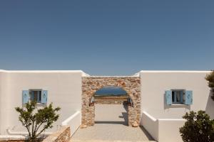 an archway in a white building with the ocean in the background at Ergina Summer Resort in Antiparos