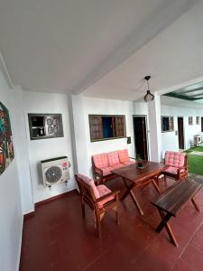 sala de estar con mesa de madera y sillas en Pousada Jardim Magico, en Natal