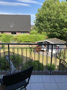 a bench sitting on a balcony with a view of a yard at NEU Ferienwohnung Hofmann in Husum