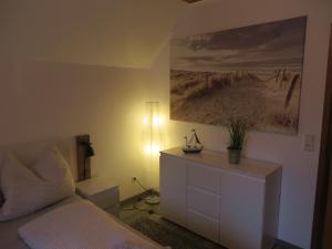a bedroom with a bed and a painting on the wall at NEU Huus Inge und Manni in Dornum