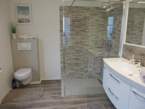 a bathroom with a shower and a toilet and a sink at NEU Huus Inge und Manni in Dornum +17 photos