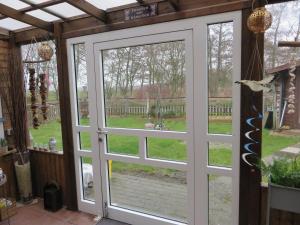 a sliding glass door with a view of a yard at NEU Huus Inge und Manni in Dornum