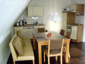 a kitchen with a dining room table and chairs at !!!NEU!!! Ferienwohnung am Deich in Dornumersiel
