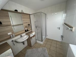 a bathroom with a sink and a shower in it at !!!NEU!!! Ferienwohnung am Deich in Dornumersiel