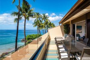 a balcony with a table and chairs and the ocean at MAKENA SURF, #G-301-302 condo in Wailea