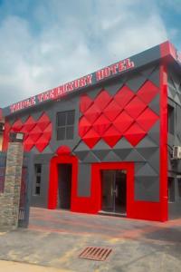 a red and gray building with a hotel at Triple Tee Hotel & Service Apartments in Ikeja
