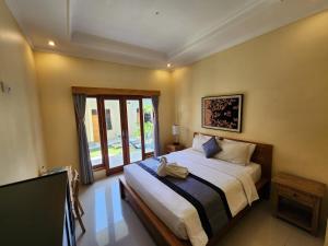 ein Schlafzimmer mit einem Bett und einem großen Fenster in der Unterkunft Double A Guest House in Canggu