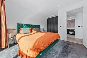a bedroom with a large bed with an orange blanket at CENTRAL LONDON STAY-Fabulous Ultra-Central London Luxury Designer One Bedroom Flat with inner garden view balcony AC and kitchen in London