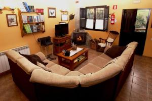 - un salon avec un grand canapé et une cheminée dans l'établissement El Ferreiru 1, Casa Rural en un Entorno Natural, à Ricabo