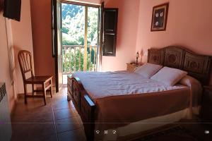 - une chambre avec un lit, une chaise et une fenêtre dans l'établissement El Ferreiru 1, Casa Rural en un Entorno Natural, à Ricabo