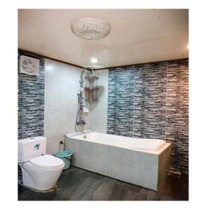 a bathroom with a bath tub and a toilet at Fely's transient house in Puerto Princesa City