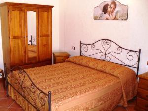 Un dormitorio con una cama y una foto de una mujer en Agriturismo La Targa, en Buonfornello