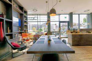 a dining room with a long table and chairs at Campanile Berlin Brandenburg Airport in Schönefeld