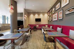 a restaurant with tables and a red couch at Campanile Berlin Brandenburg Airport in Schönefeld