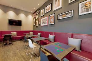 a dining room with red booths and tables at Campanile Berlin Brandenburg Airport in Schönefeld
